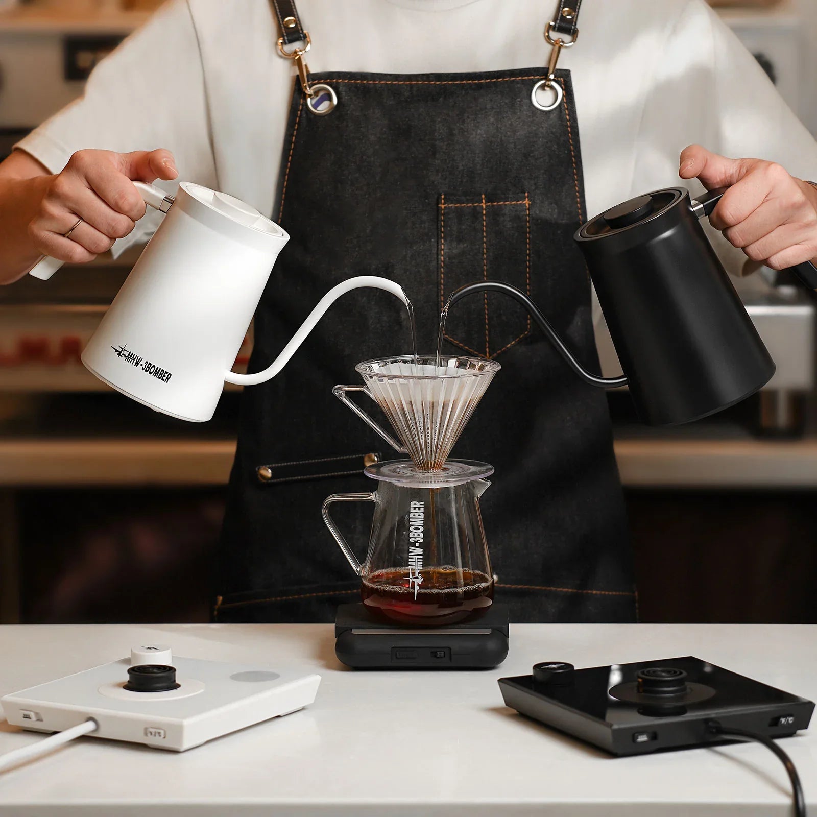Two gooseneck kettle pouring water in V60