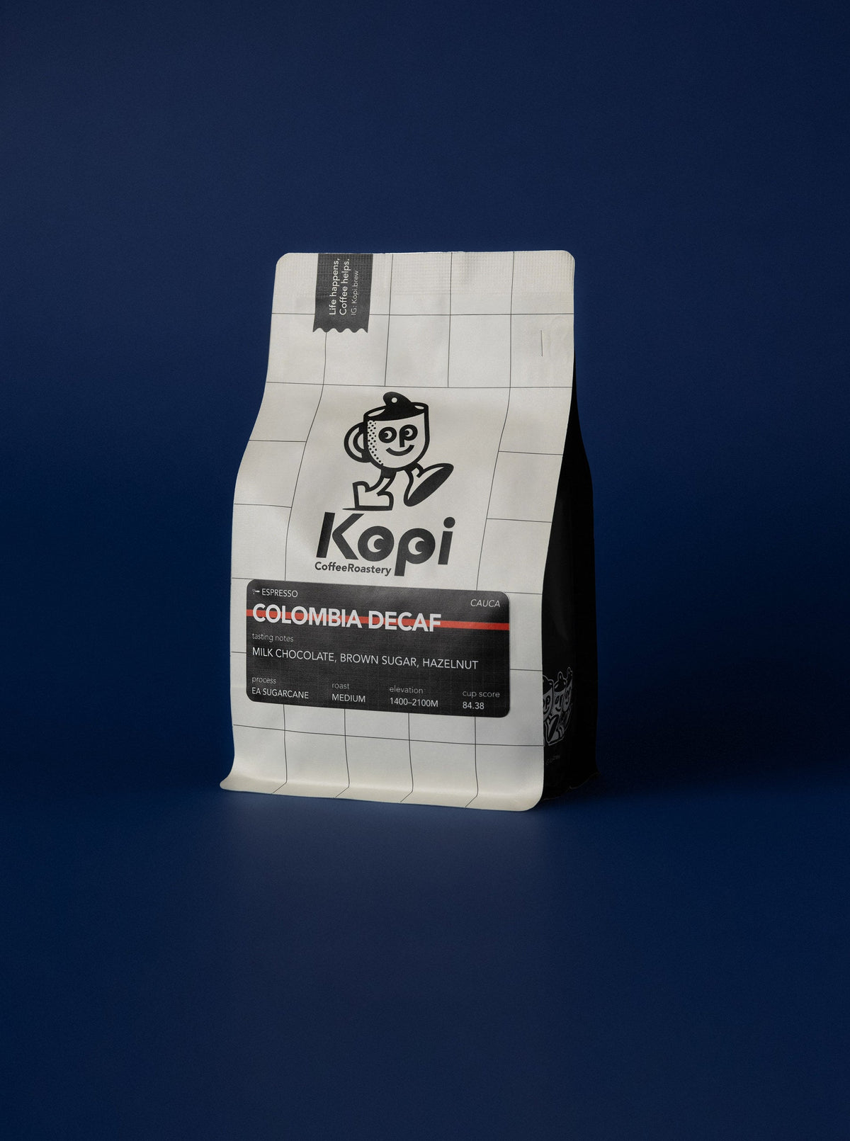 KOPI Colombia decaf espresso coffee bag against a blue background.