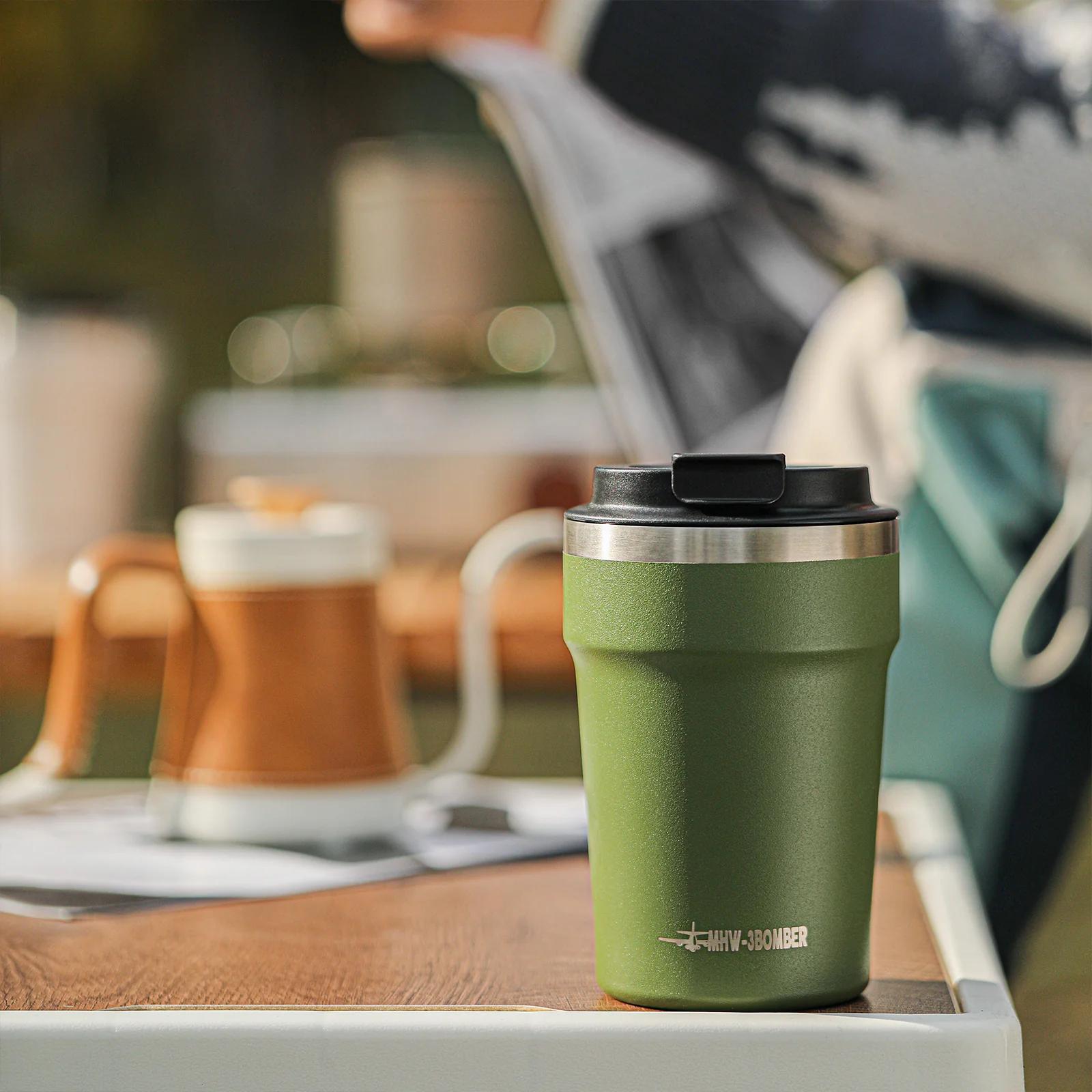 Green insulated tumbler on a table with a blurred outdoor background