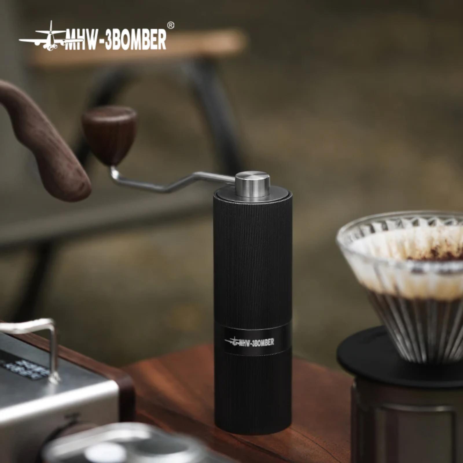 Black manual coffee grinder on a wooden table with blurred background