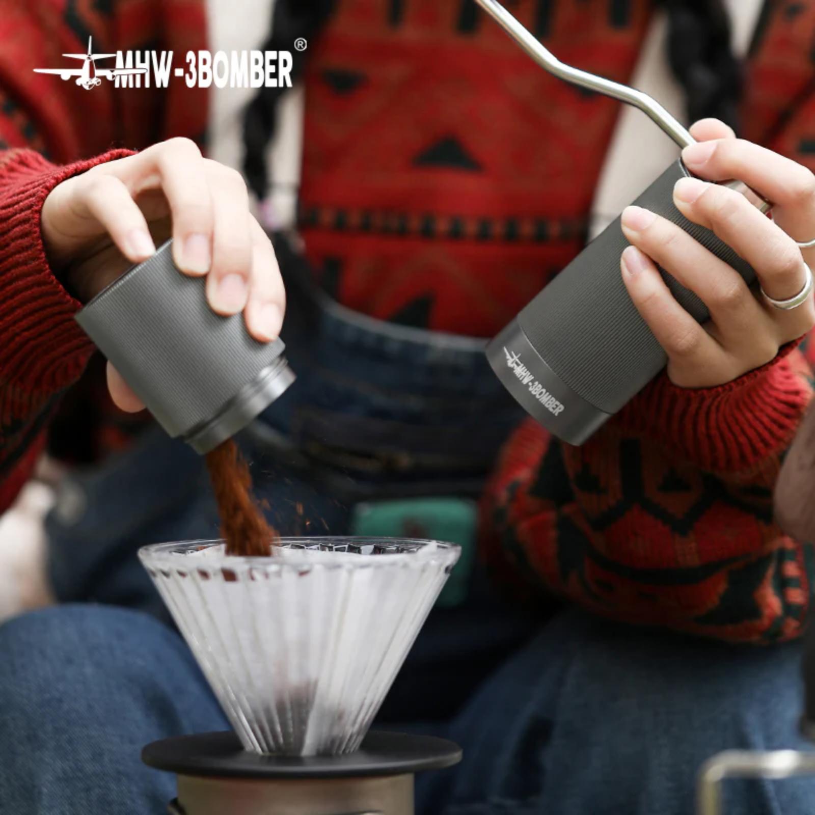 Two people using portable coffee makers to pour coffee into a filter cup, with 'MHW-3BOMBER' branding.